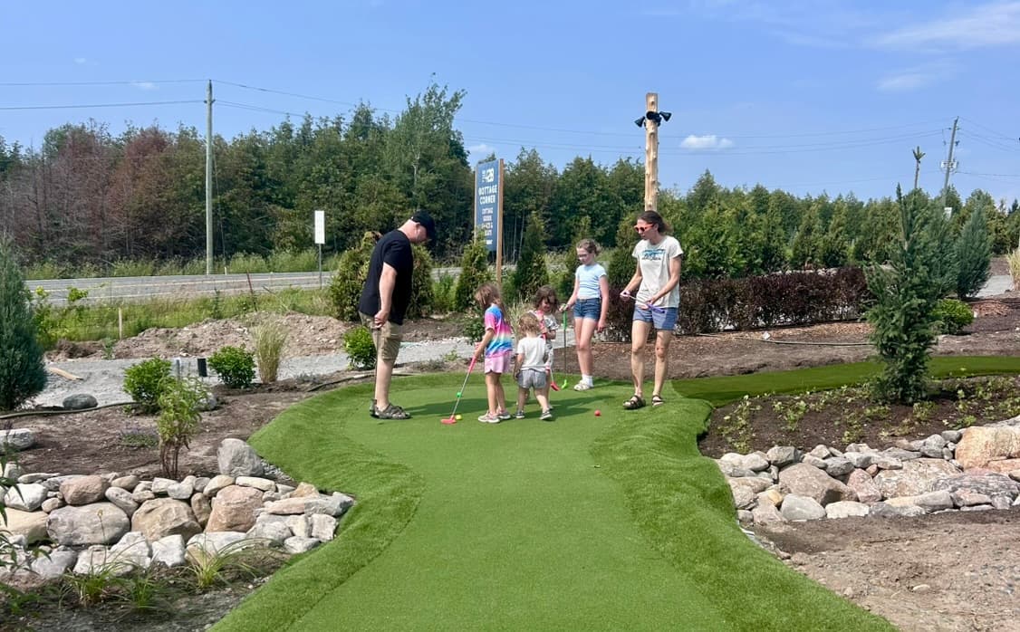 A family playing mini golf together on the course